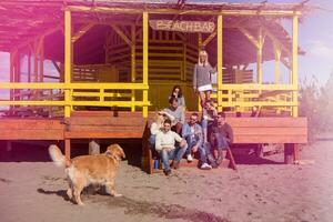 grupp av vänner har roligt på höst dag på strand foto