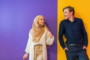 porträtt av ung muslim par kvinna i modern klänning med hijab isolerat på färgrik bakgrund representerar modern islam mode och ramadan kareem begrepp foto