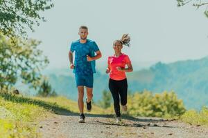 par njuter i en friska livsstil medan joggning på en Land väg genom de skön solig skog, övning och kondition begrepp foto