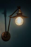 gammal ljus Glödlampa på en modern blå vägg. selektiv fokus foto