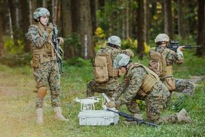 modern krigföring soldater trupp är använder sig av Drönare för scouting och övervakning under militär drift i de skog. foto