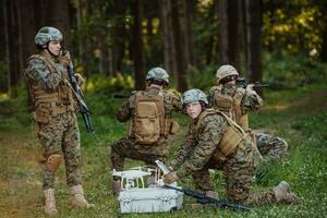 modern krigföring soldater trupp är använder sig av Drönare för scouting och övervakning under militär drift i de skog. foto