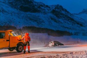 de vid vägkanten bistånd service dragande de bil ut av de kanal. ett incident på en frysta scandinavian väg. foto