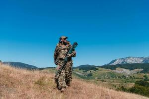 armén soldat innehav en prickskytt gevär med omfattning och gående i de skog. krig, armé, teknologi och människor begrepp. foto