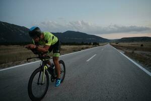 triathlon atlet cyklar på natten foto