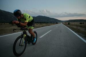 triathlon atlet cyklar på natten foto