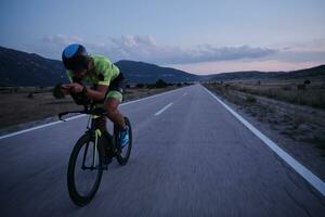 triathlon atlet cyklar på natten foto