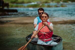par äventyrlig explorer vänner är paddla kanot i en vild flod omgiven förbi de skön natur foto