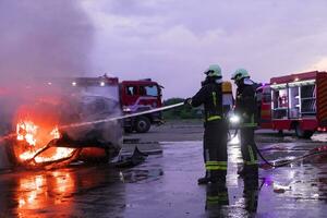 brandmän bekämpa de brand flamma till kontrollera brand inte till spridning ut. brandman industriell och offentlig säkerhet begrepp. trafik eller bil olycka rädda och hjälp handling. foto