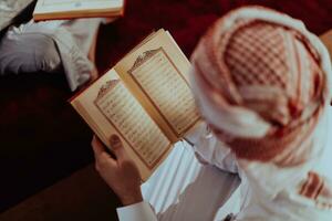 en grupp av muslims läsning de helig bok av de quran i en modern moské under de muslim Semester av ramadan foto