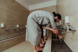 en muslim utför ablution. ritual religiös rensning av muslims innan utför bön. de bearbeta av rensning de kropp innan bön foto