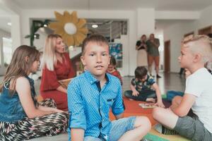 läsning tid i ett elementärt skola eller dagis, en lärare läser en bok till barn i ett elementärt skola eller dagis. de begrepp av förskola utbildning. selektiv fokus foto