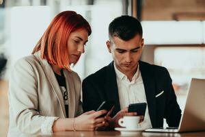 modern man och kvinna använda sig av modern enheter, bärbar dator, läsplatta och smartphone i coffe affär foto