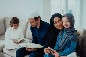 Lycklig muslim familj njuter de helig månad av ramadan medan bön- och läsning de quran tillsammans i en modern Hem foto