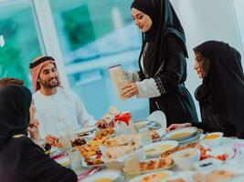 eid mubarak muslim familj har iftar middag dricka vatten till ha sönder fest. äter traditionell mat under ramadan festande månad på Hem. de islamic halal äter och dricka foto