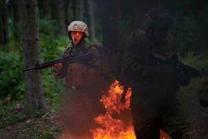 soldat i verkan på natt Hoppar över brand foto