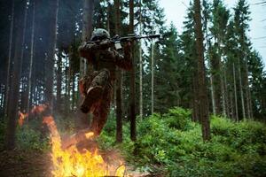 soldat i verkan på natt Hoppar över brand foto