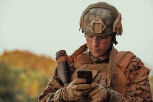 soldat använder sig av smartphone till Kontakt familj eller flickvän kommunikation och nostalgi begrepp foto