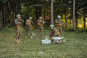 modern krigföring soldater trupp är använder sig av Drönare för scouting och övervakning under militär drift i de skog. foto