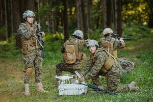 modern krigföring soldater trupp är använder sig av Drönare för scouting och övervakning under militär drift i de skog. foto