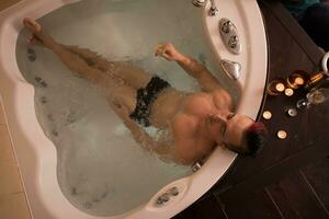 man avkopplande i de jacuzzi foto