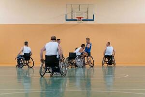 handikappade krig veteraner i rullstolar med professionell Utrustning spela basketboll match i de hall.the begrepp av sporter med funktionshinder foto