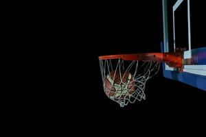 basketboll och nät på svart bakgrund foto