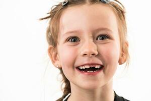 porträtt av en liten flicka på en vit bakgrund med friska, utvecklande tänder foto
