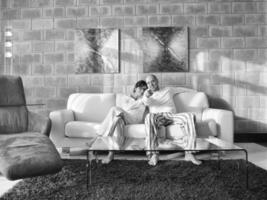 avslappnad ung par tittar på TV på Hem foto