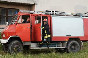 grupp av brand kämpar stående självsäker efter en väl Gjort rädda drift. brandmän redo för nödsituation service. foto