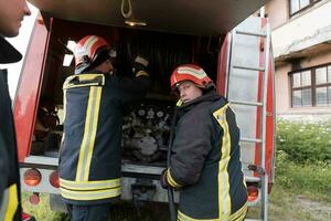 grupp av brand kämpar stående självsäker efter en väl Gjort rädda drift. brandmän redo för nödsituation service. foto