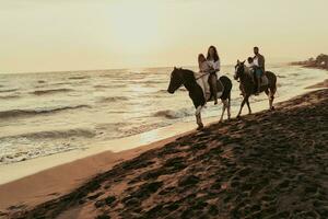 de familj spenderar tid med deras barn medan ridning hästar tillsammans på en sandig strand. selektiv fokus foto