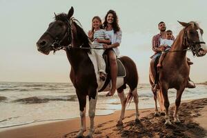 de familj spenderar tid med deras barn medan ridning hästar tillsammans på en sandig strand. selektiv fokus foto