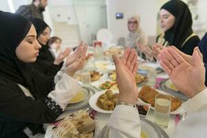 muslim familj framställning iftar dua till ha sönder fasta under ramadan. foto