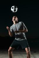 porträtt av en ung stilig fotboll spelare man på en gata spelar med en fotboll boll. foto