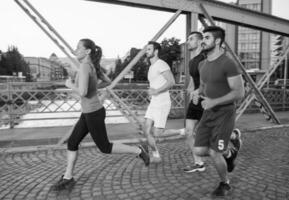 grupp unga människor som joggar över bron foto