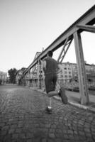 man joggar över bron på solig morgon foto
