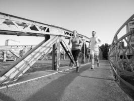 ungt par joggar över bron i staden foto