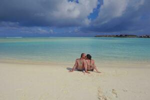 Lycklig ung par på sommar semester ha roligt och koppla av på strand foto