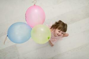 söt liten flicka spelar med ballonger foto