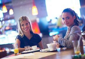 flickor ha kopp av kaffe i restaurang foto