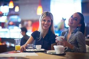 flickor ha kopp av kaffe i restaurang foto