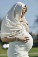Lycklig ung gravid kvinna utomhus- foto