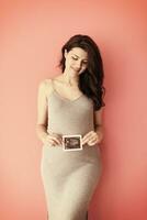 lycklig gravid kvinna som visar ultraljudsbild foto