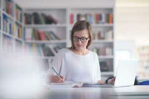 kvinna studerande studie i skola bibliotek foto