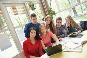 Lycklig tonåren grupp i skola foto