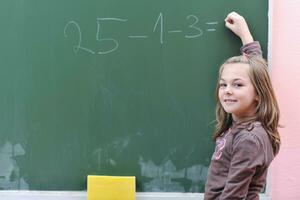 Lycklig skola flicka på matematik klasser foto