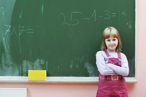 Lycklig skola flicka på matematik klasser foto