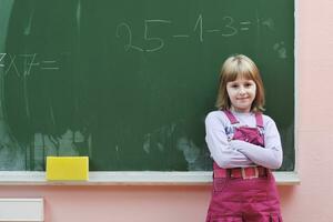 Lycklig skola flicka på matematik klasser foto