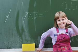 Lycklig skola flicka på matematik klasser foto